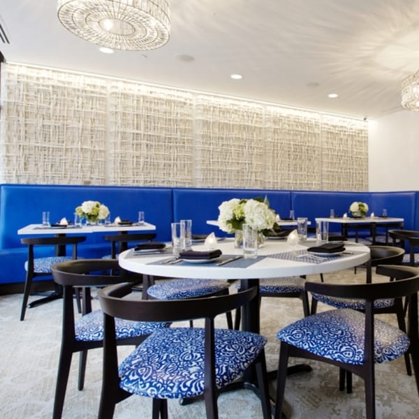 All Set Restaurant & Bar dining room with blue booths, round tables, and patterned chairs.