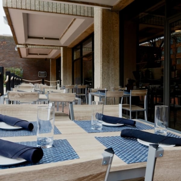 Outdoor patio dining area at All Set Restaurant & Bar, with set tables and chairs.