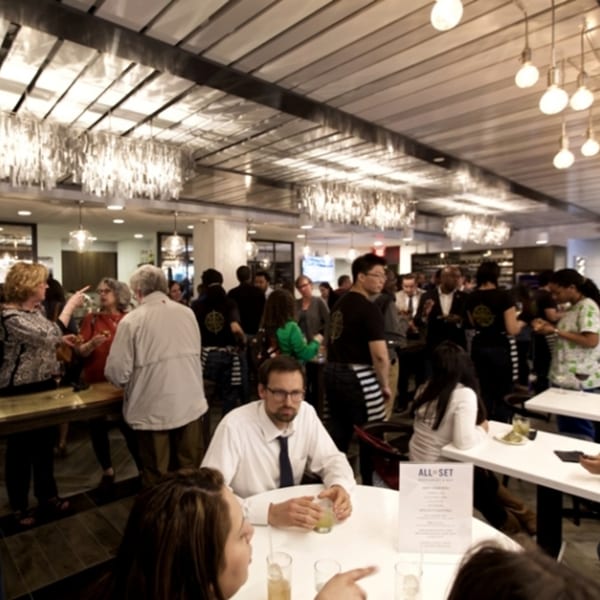 All Set Restaurant & Bar dining room filled with guests, some seated at tables, others standing and mingling.