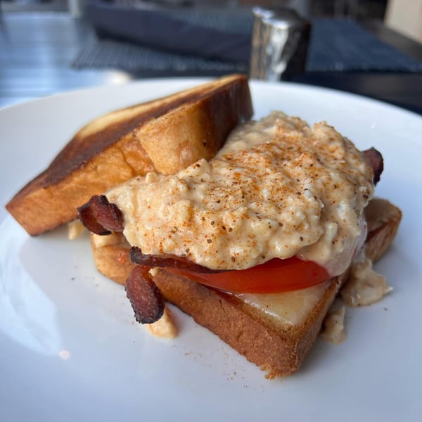 All Set's seafood sandwich with creamy topping, bacon, and tomato on toasted bread.