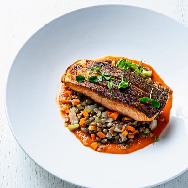 All Set Restaurant & Bar's pan-seared salmon with crispy skin, lentils, diced vegetables, and red sauce.