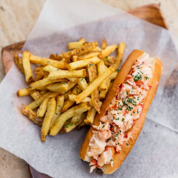 All Set Restaurant & Bar's lobster roll with fries on parchment paper.